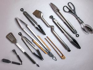 A variety of tongs displayed on a white surface