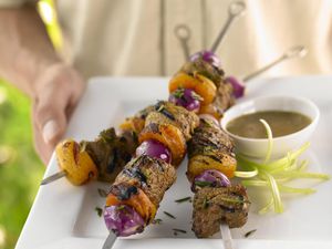 Shish kebabs on metal skewers with dipping sauce