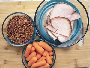 Anchor Hocking TrueSeal Food Storage Containers displayed on a wooden cutting board full of food 