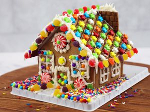 Hasbro Candyland Gingerbread House Kit displayed on a wooden surface fully assembled 