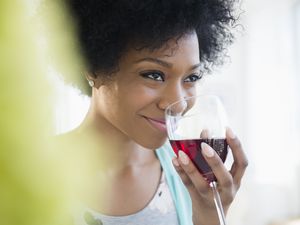 African American woman drinking glass of wine