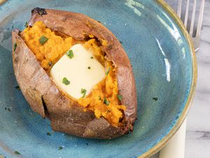 air fryer sweet potato with butter and cilantro garnish