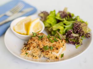 Baked halibut and Parmesan crumb topping on a white plate