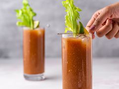 Bloody Maria Cocktail in glasses, garnished with lemon and lime wedge and celery stalks