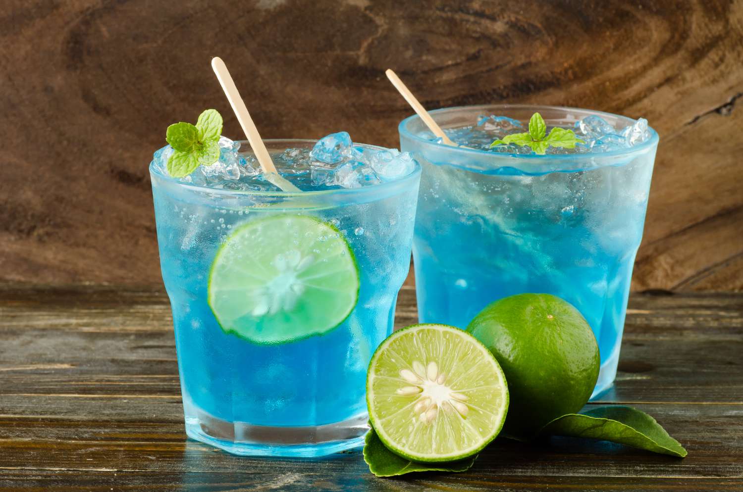 Blue Lagoon Punch in two glasses with a half of a lime off to the side