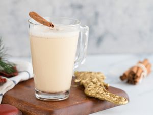 A bourbon eggnog for a holiday party with a cinnamon stick on top 