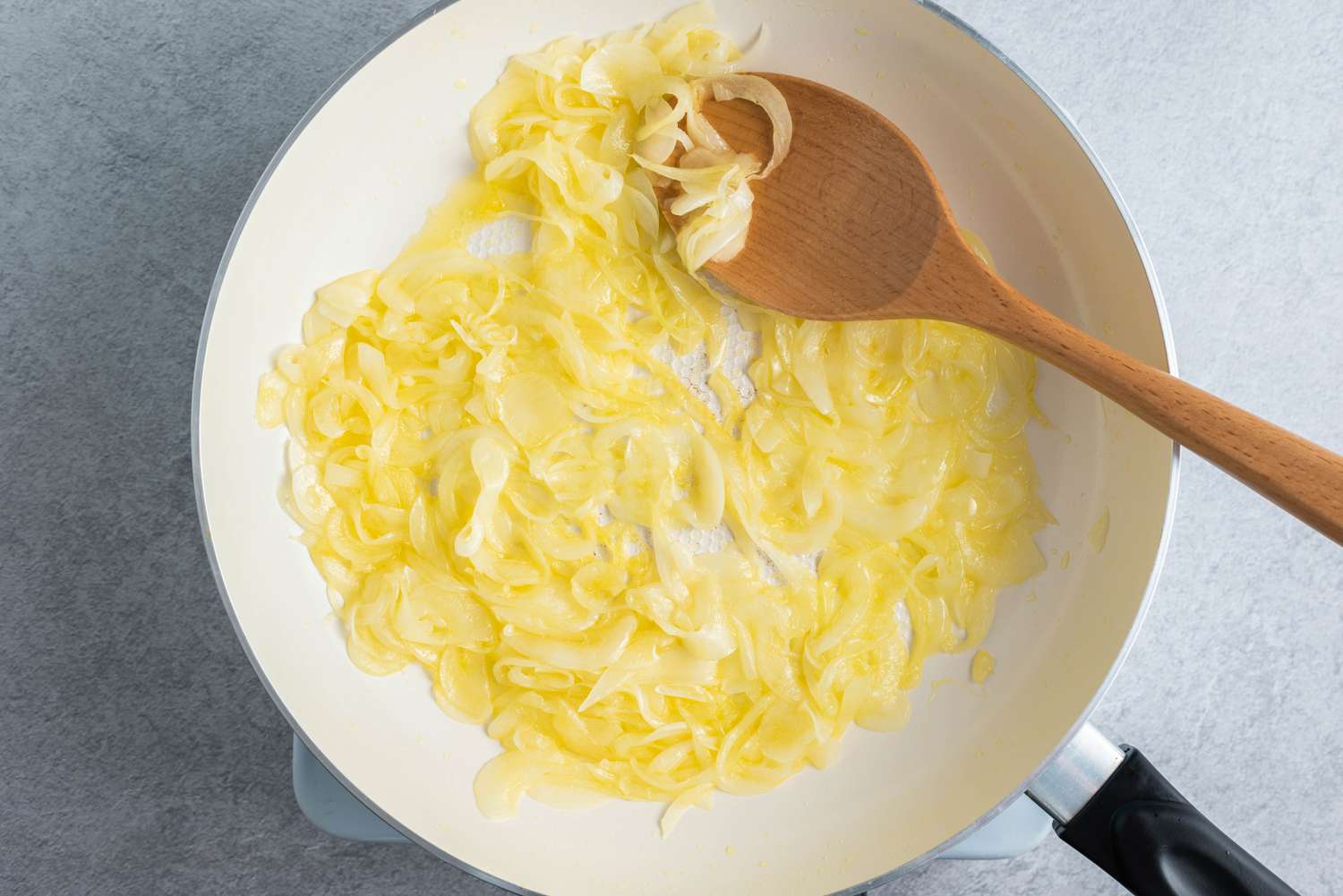 sliced onions cooked with butter in a large frying pan