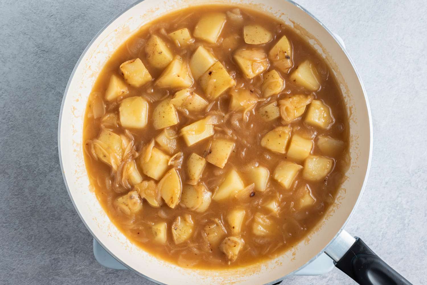 beef stock with potatoes and onions in a large frying pan