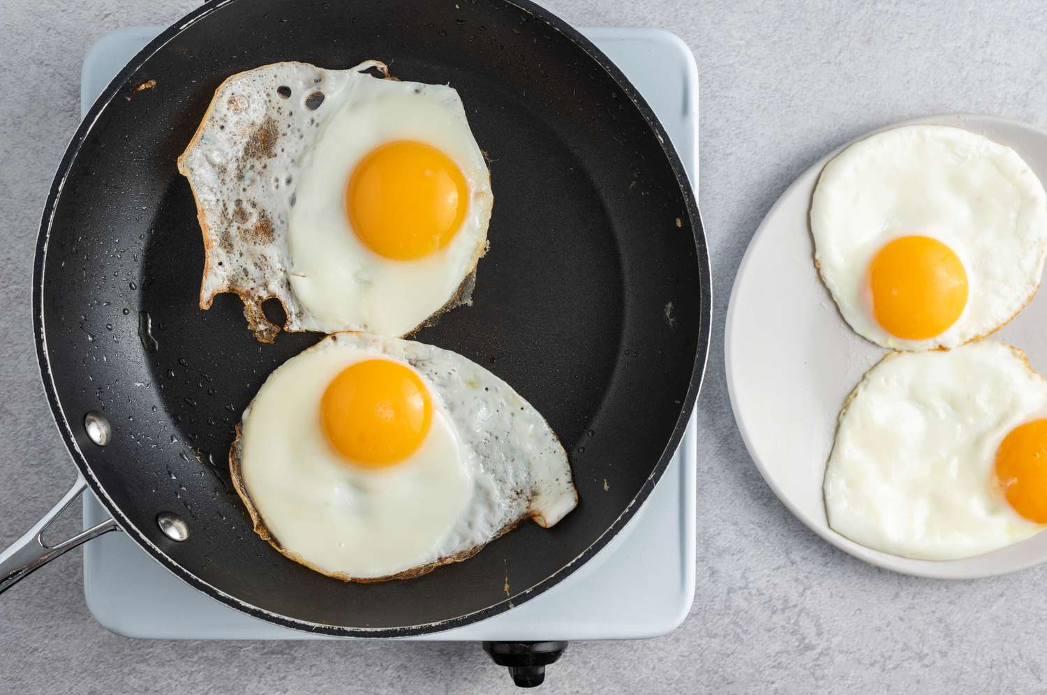 sunny side up eggs in a black non-stick pan