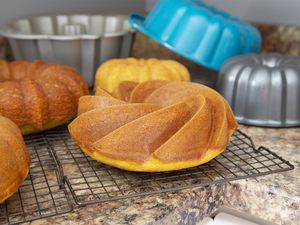 Several bundt cakes and bundt pans on a kitchen counter