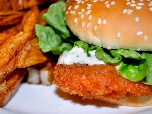 A chicken cutlet sandwich with fries