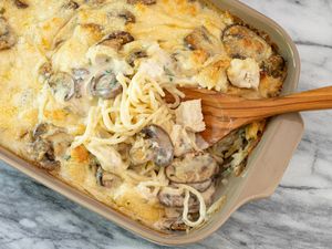 Chicken tetrazzini casserole in baking dish with spoon.