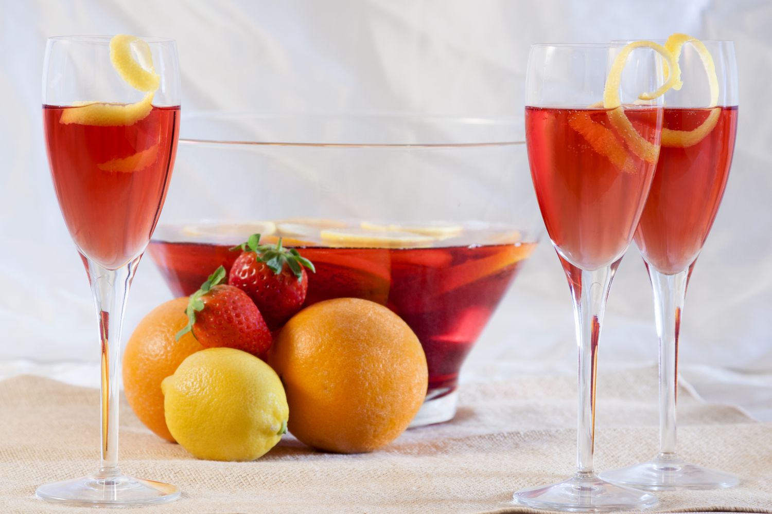 Cranberry Elderflower Champagne Punch in Champagne glasses and a punch bowl