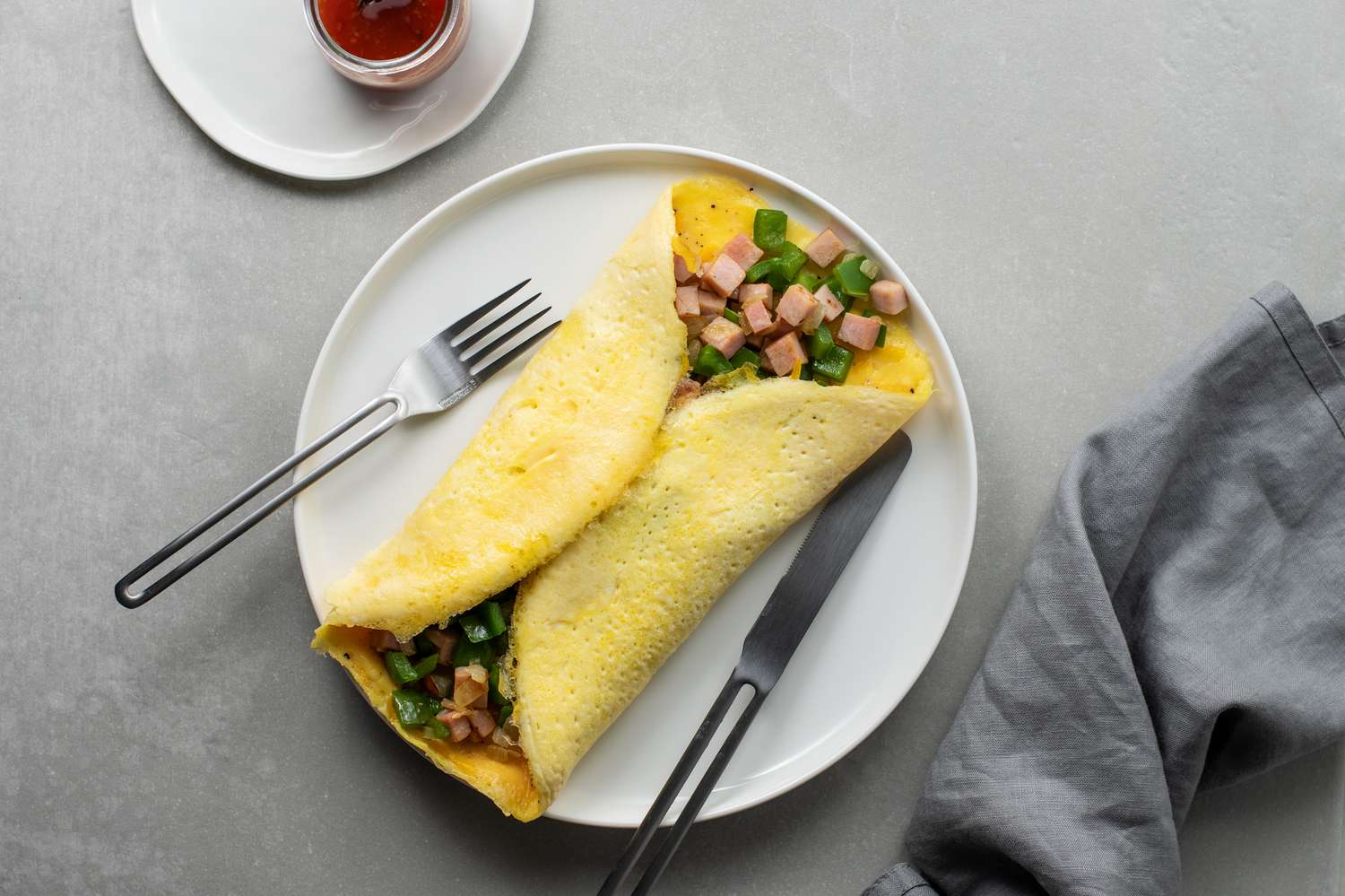 Denver omelet filled with diced ham and green bell pepper on a plate