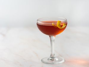 Dubonnet cocktail in a glass with a lemon twist