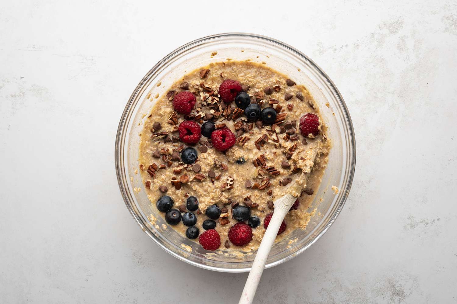 Oatmeal with betties and nuts in a bowl, with a wooden spoon 