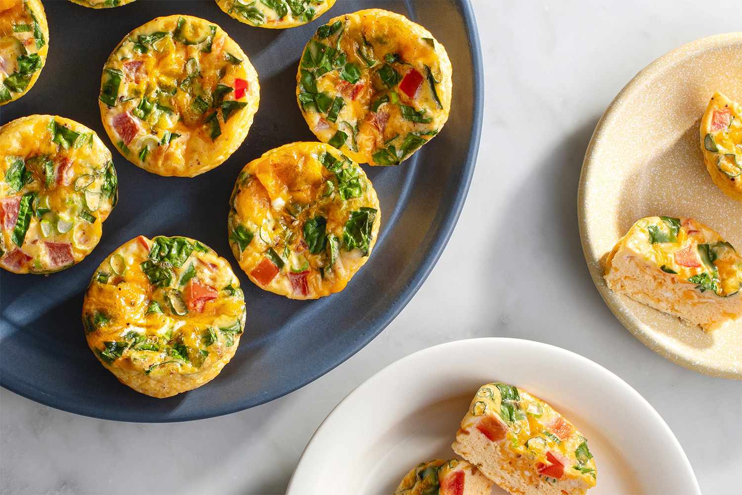 Easy oven egg bites on a steel-blue platter and on light plates 