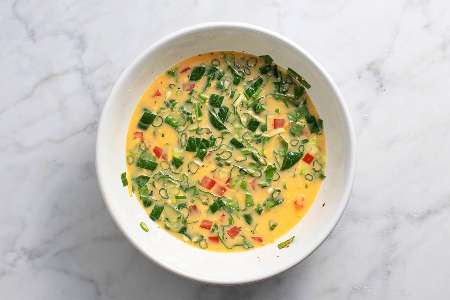 Eggs and vegetable mixture in a white bowl 