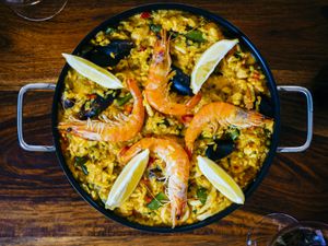 Fresh paella in pan on wooden table