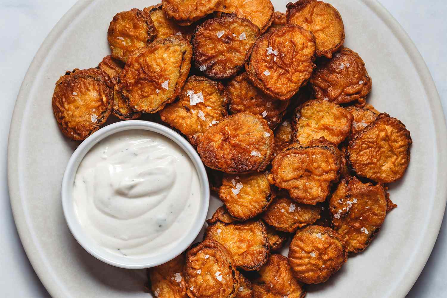 Fried Pickles on a platter with sauce 