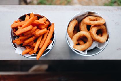 Sweet potato french fries and onion rings on a window sill