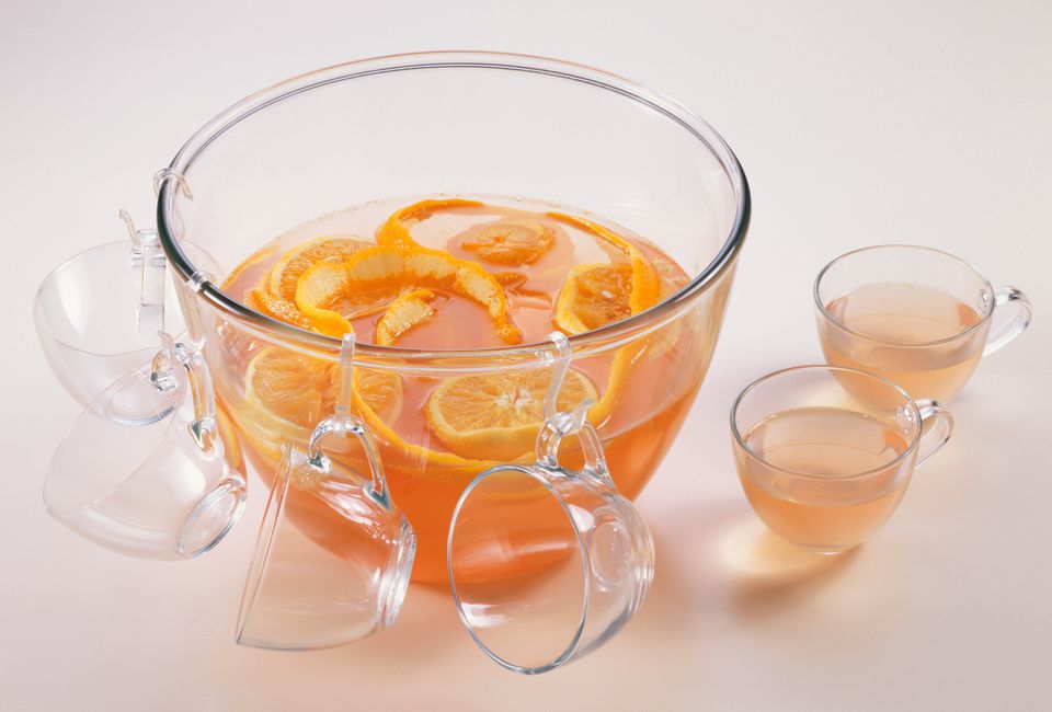 Fruit Punch in a bowl with glasses with hooks hanging off of the bowl