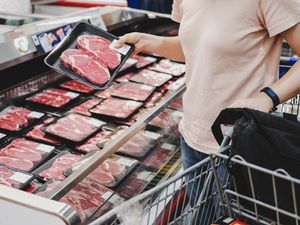 person shopping for meat at grocery store