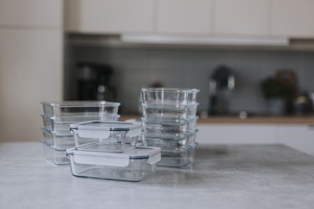 A pile of glass storage containers on a kitchen island. 