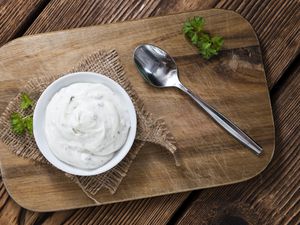 sour cream dip in bowl on wooden board