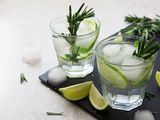 Gin and tonic with lime and rosemary on a slate board