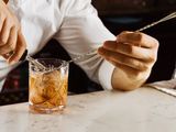 Bartender using a barspoon to make a drink.