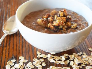 Gingerbread oatmeal in a white bowl garnished with nuts