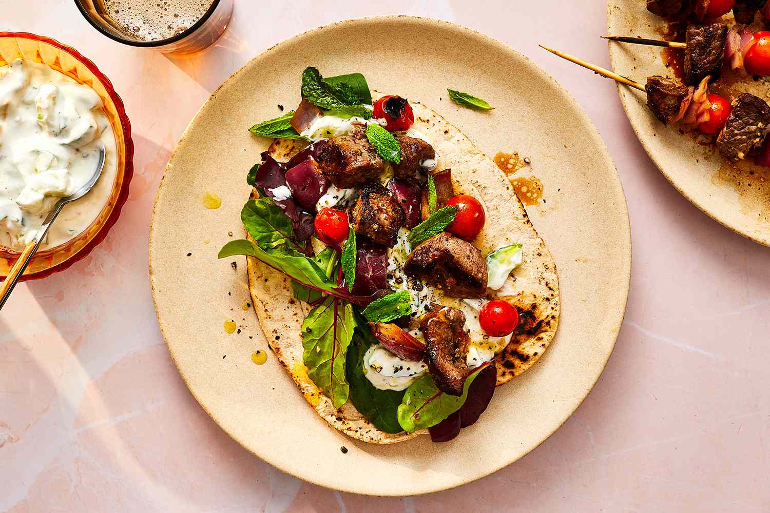 Greek Style Lamb Kabobs With Pita on a plate and Tzatziki Sauce in a bowl on the side