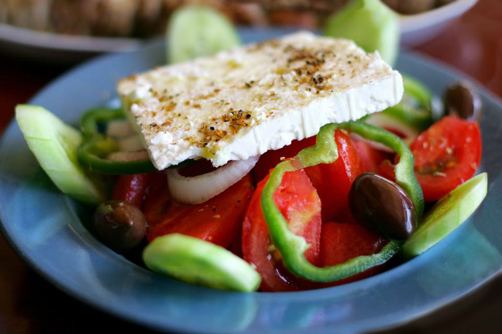 A fresh Greek salad resting in a blue bowl