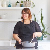 Theodora Kaloudis standing in front of a stove stirring a pot