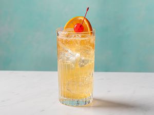 John Collins bourbon whiskey highball with orange slice and cherry garnishes