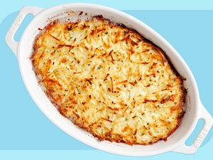 A golden brown shredded potato gratin in an oblong Staub baking dish