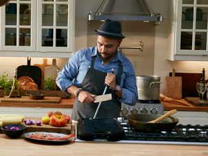 A man sharpening a knife in the kitchen