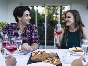 Man and woman having fun and drinking lambrusco wine during a summer dinner