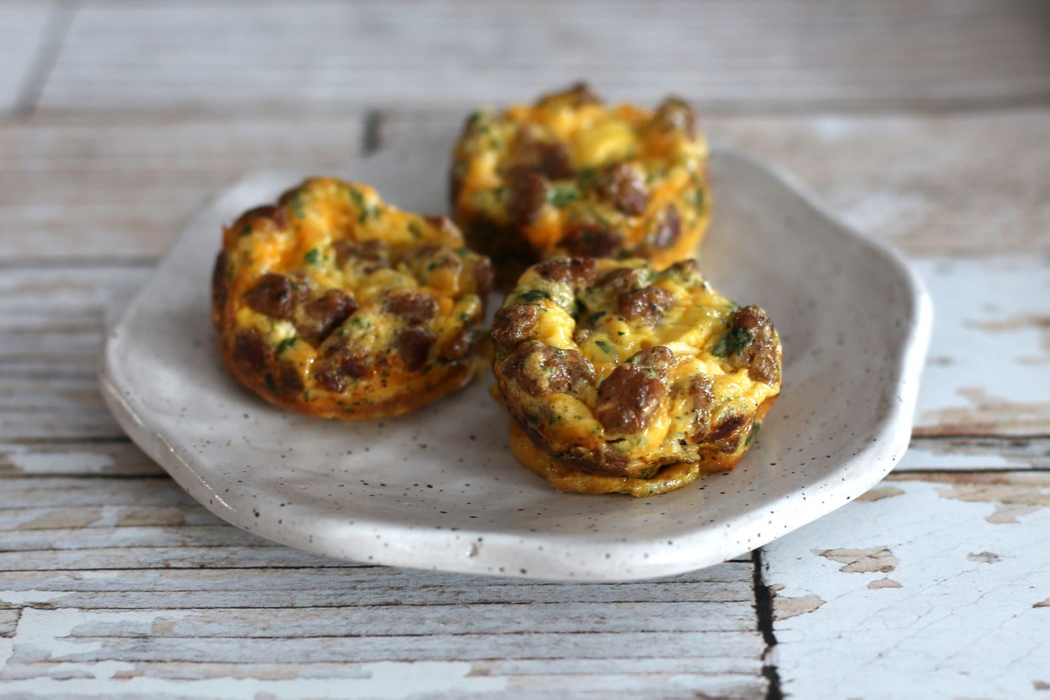 Three mini sausage frittatas sitting on a plate