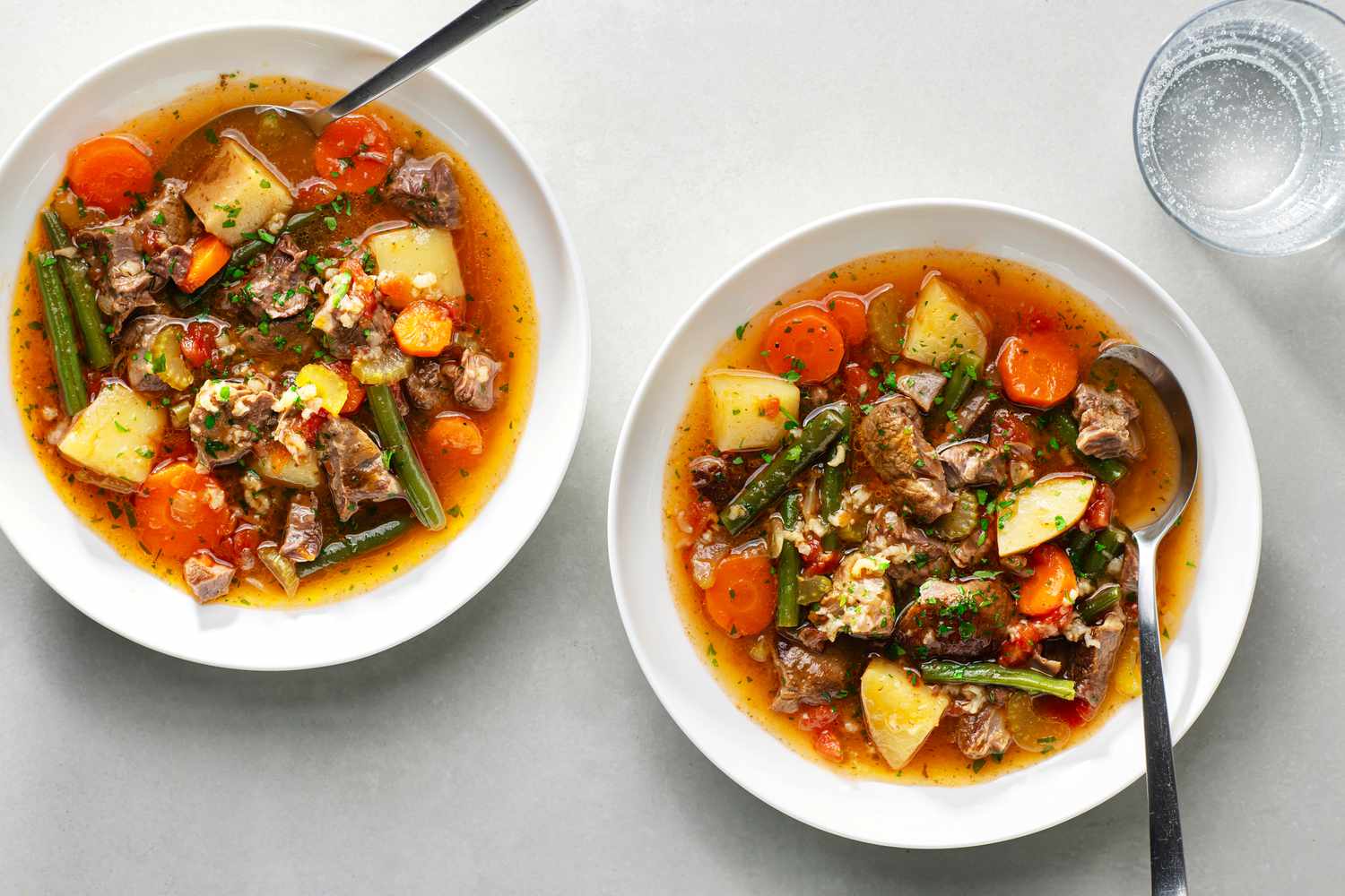 Two white bowls filled with old-fashioned vegetable beef soup