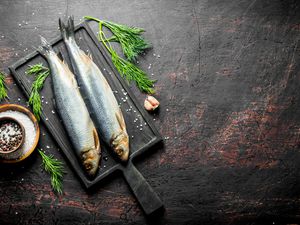 Herring on a cast iron skillet with herbs and salt