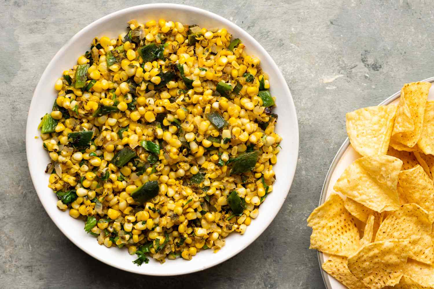 Roasted Chili Corn Salsa in a bowl, served with a side of chips 