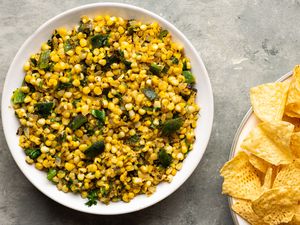 Roasted Chili Corn Salsa in a bowl, served with a side of chips 