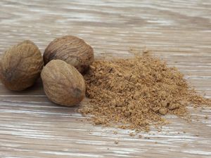 Nutmeg nuts next to ground nutmeg