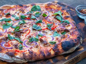 italian sausage pizza with red bell pepper and thin sliced red onion