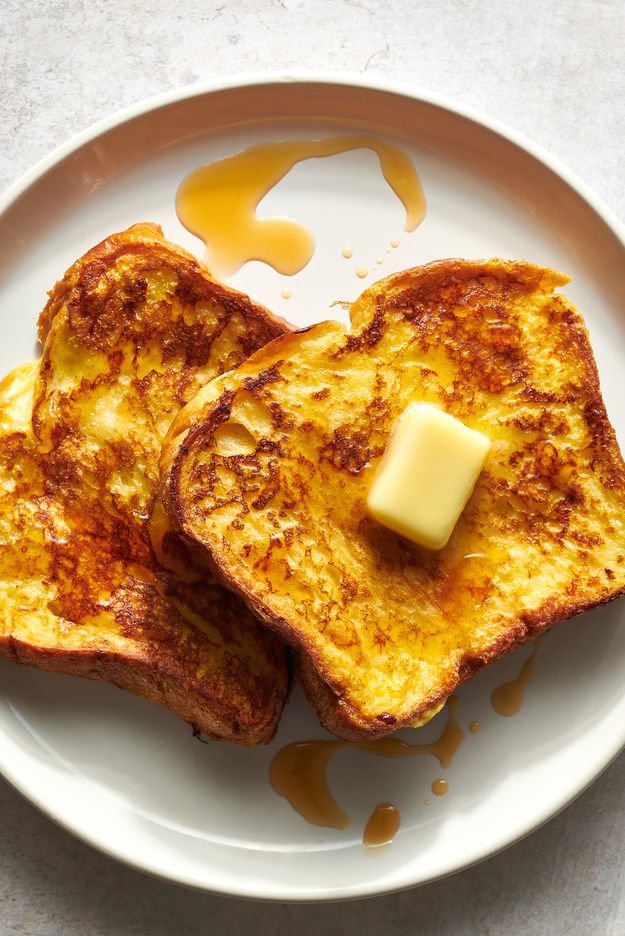 French toast served with butter, syrup, and berries