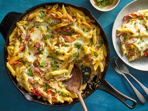 A chicken fajita pasta bake in a skillet, served with extra cilantro on the side