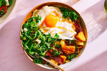 A bowl of First Watch's Million Dollar Harvest Hash, topped with a fried egg and honey