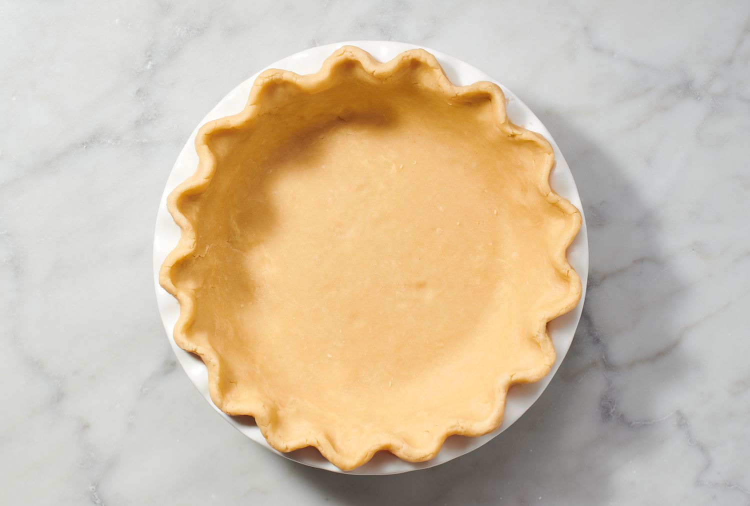 A crimped-edge dough pie crust in a pie plate